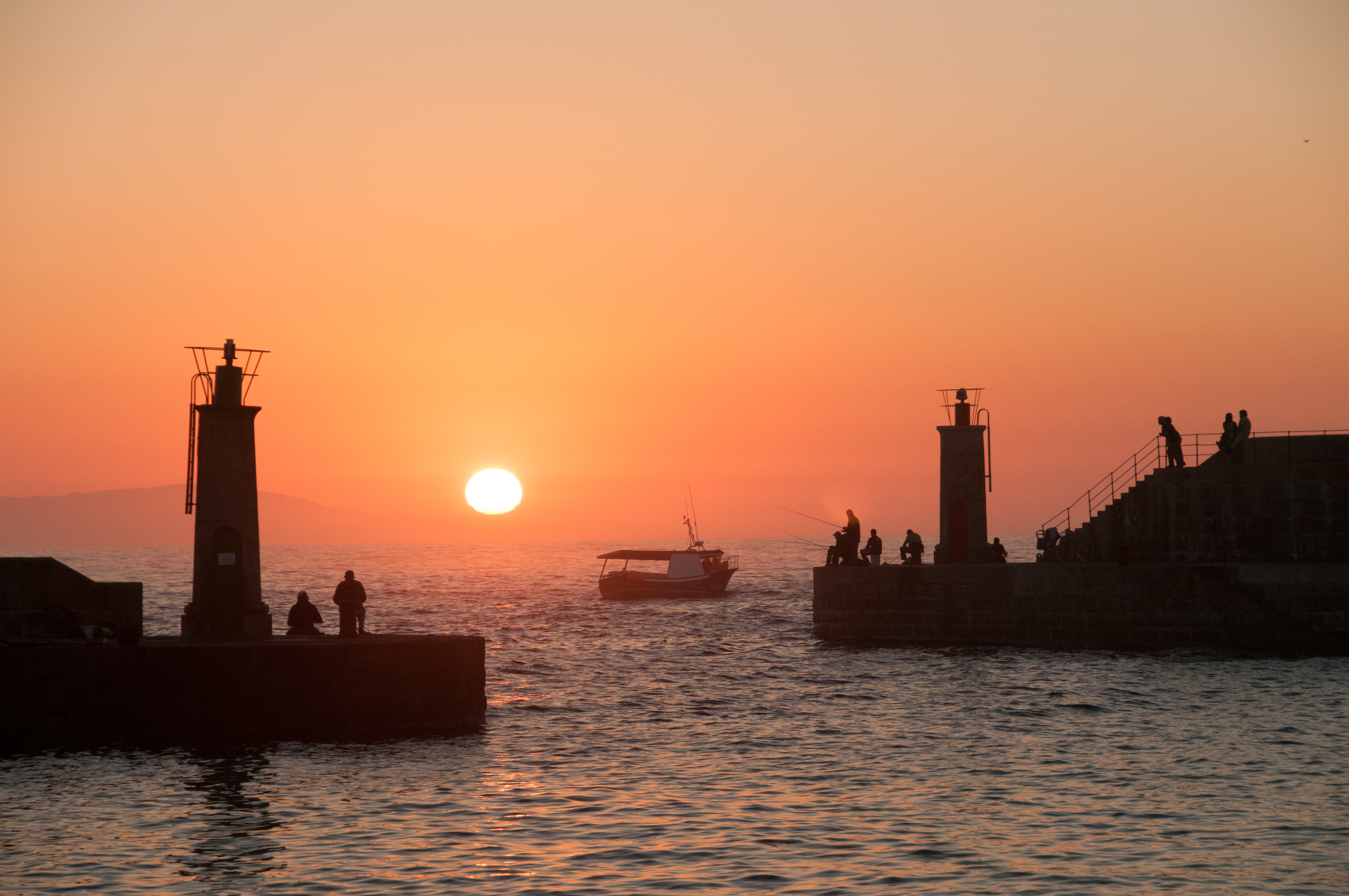 Puesta de sol en Tapia de Casariego con los faros del muelle al fondo