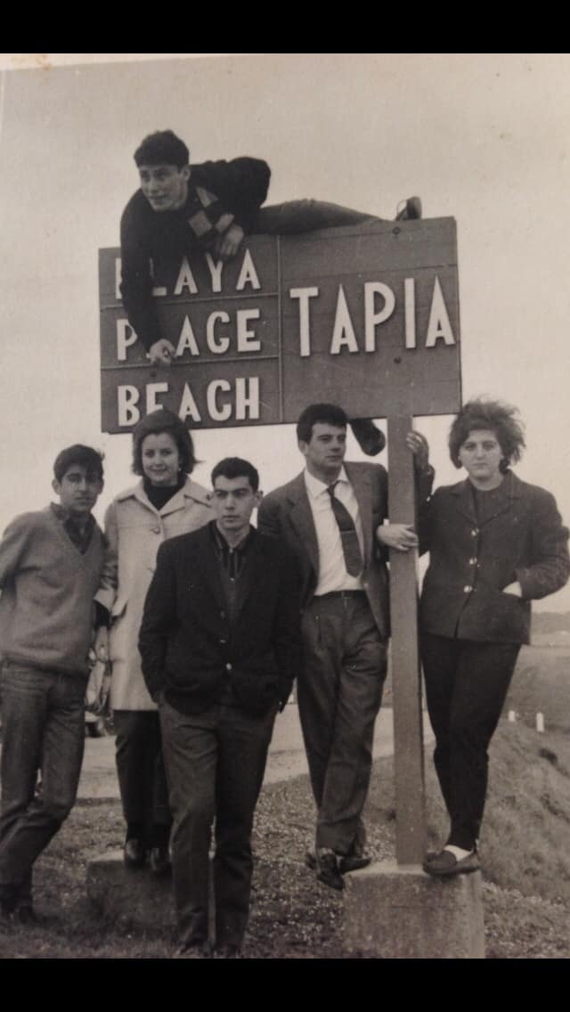 Grupo de amigos en el cartel de la playa de Tapia