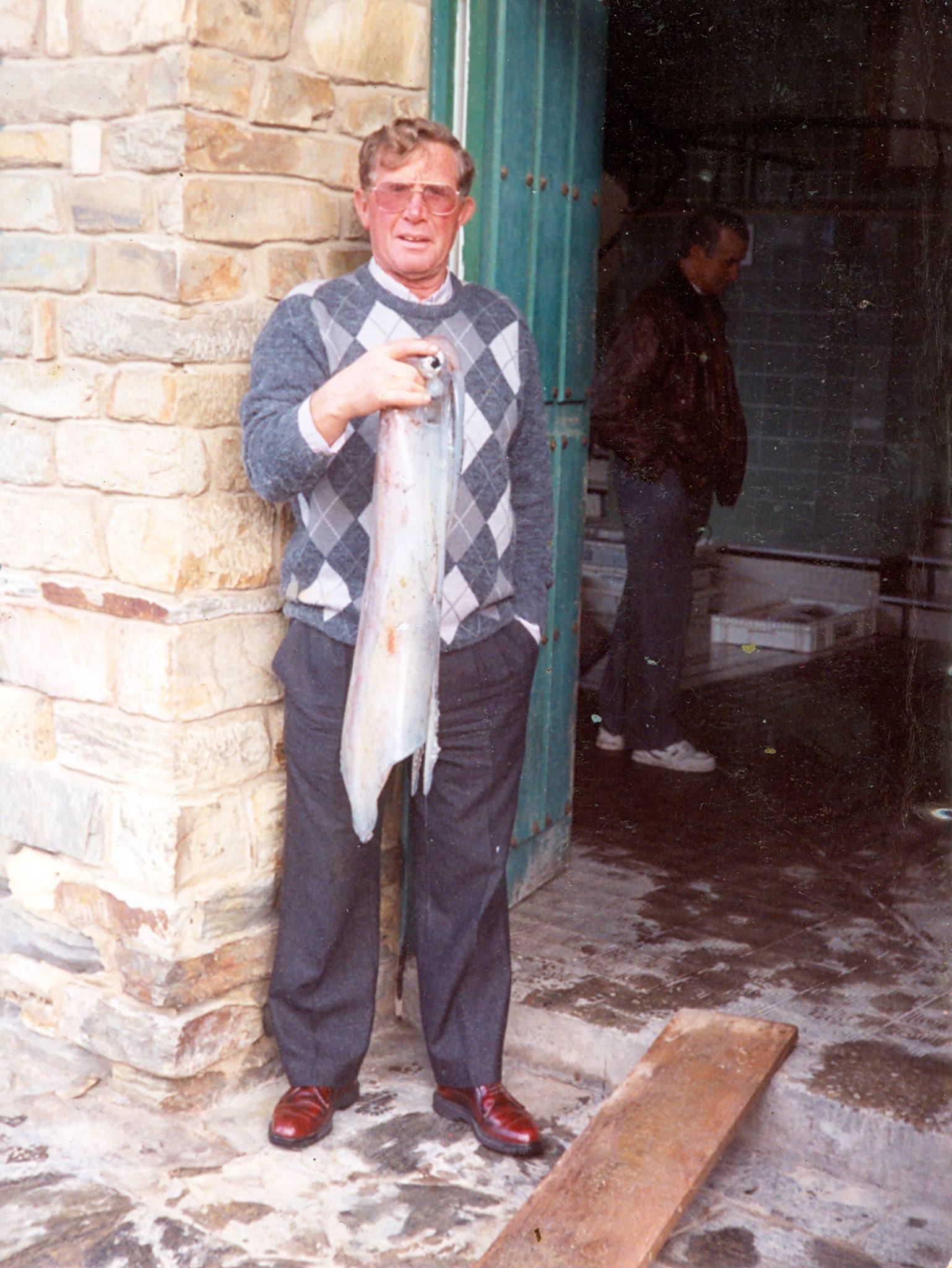 Tolito a la entrada de la rula posando con un gran calamar