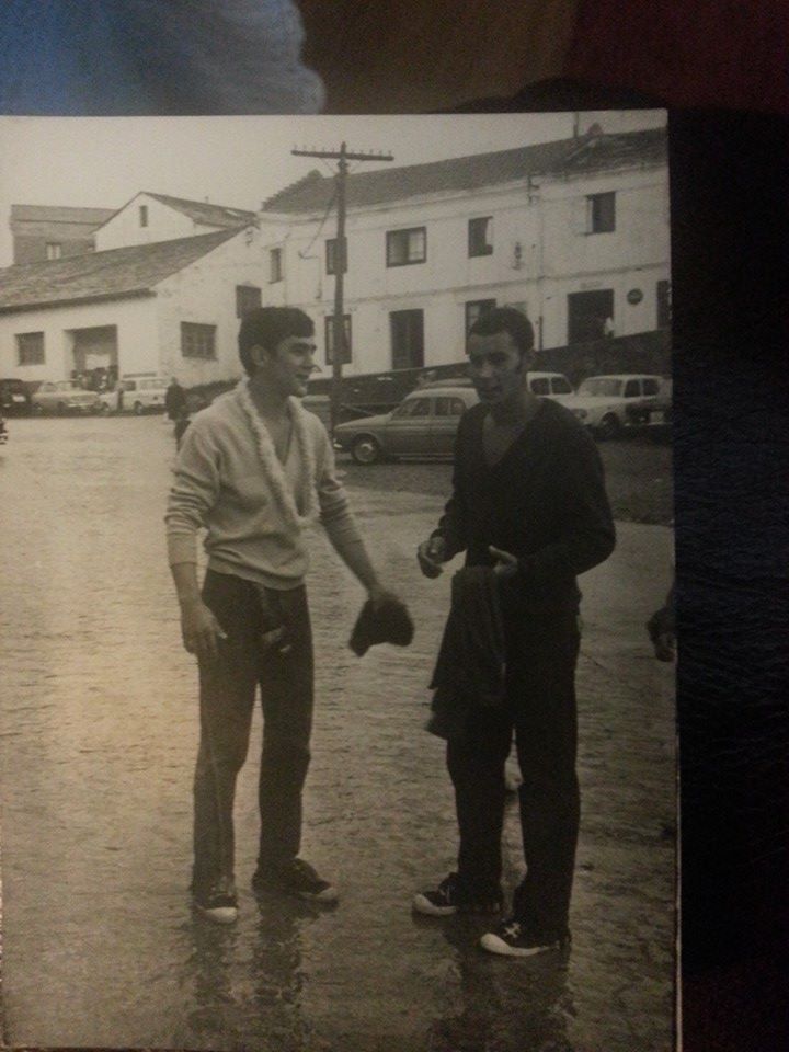 Dos tapiegos falando en el muelle al fondo el edificio de la Marina