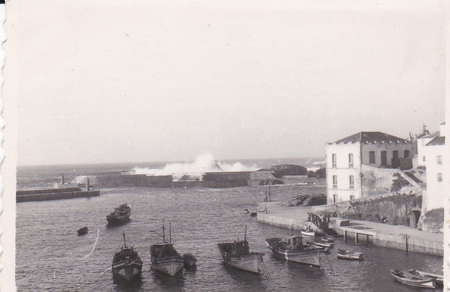 Muelle de Tapia con olas saltando por el faro rojo
