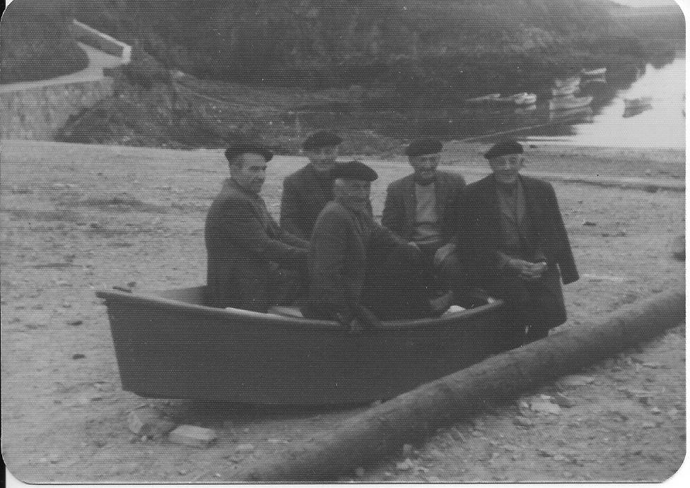 Marineros jubilados sentados en un chalano en el muelle