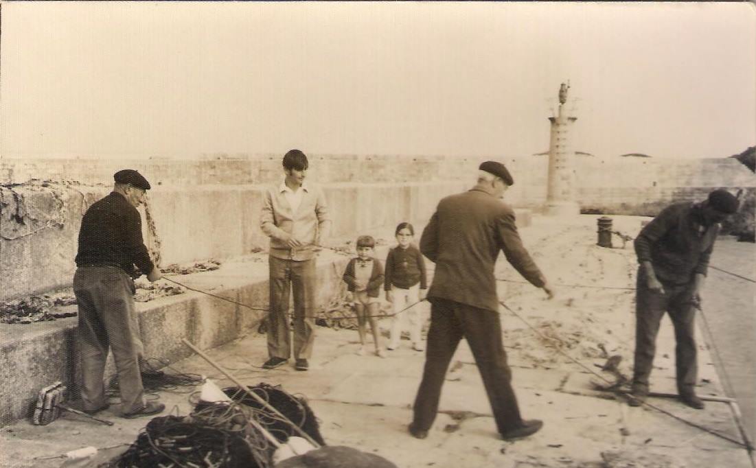 Marineros limpiando sus redes en el muelle del Rocín