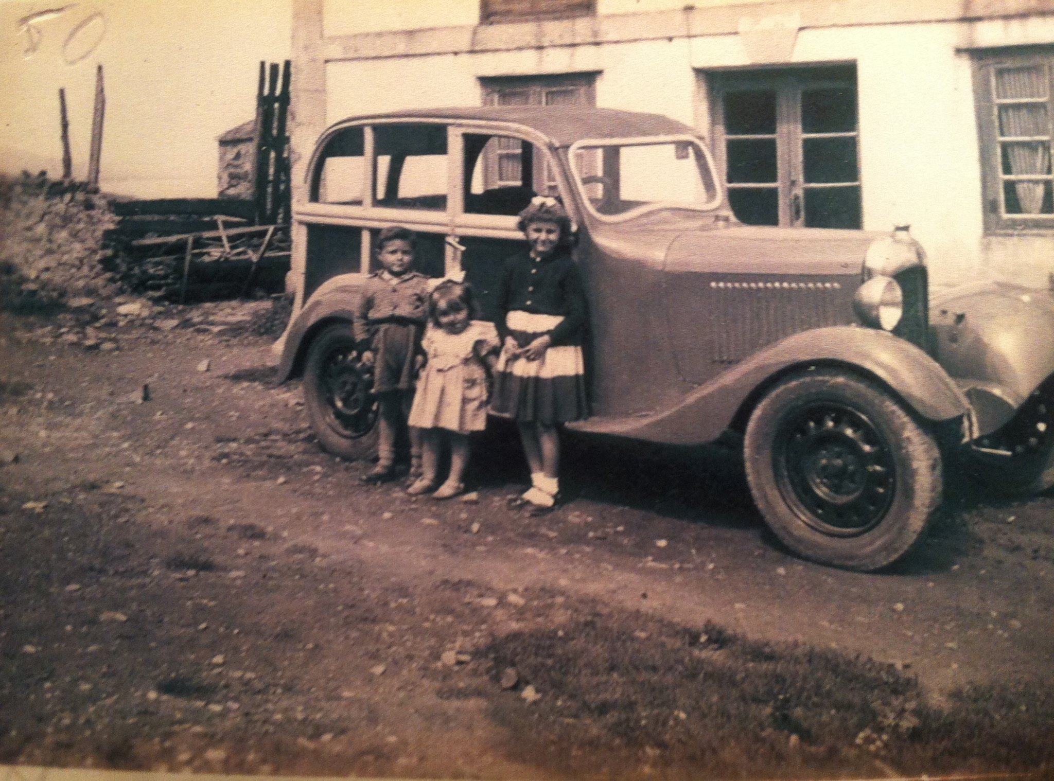 Grupo de niños junto a un coche de época en Tapia de Casariego