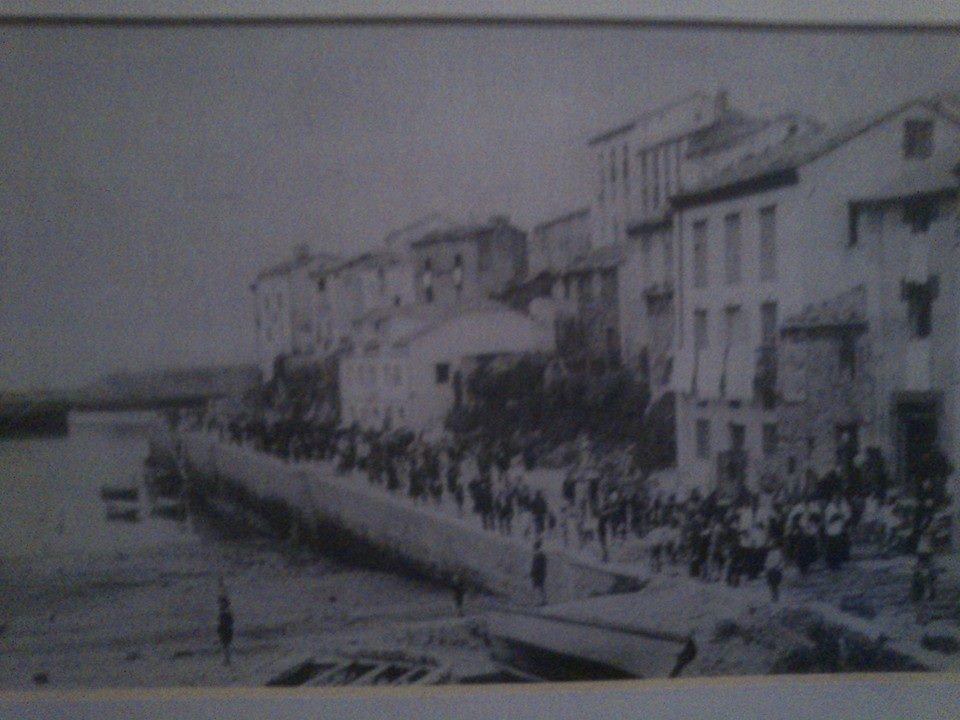 Grupo de locales y veraneantes en el muelle de Tapia de Casariego