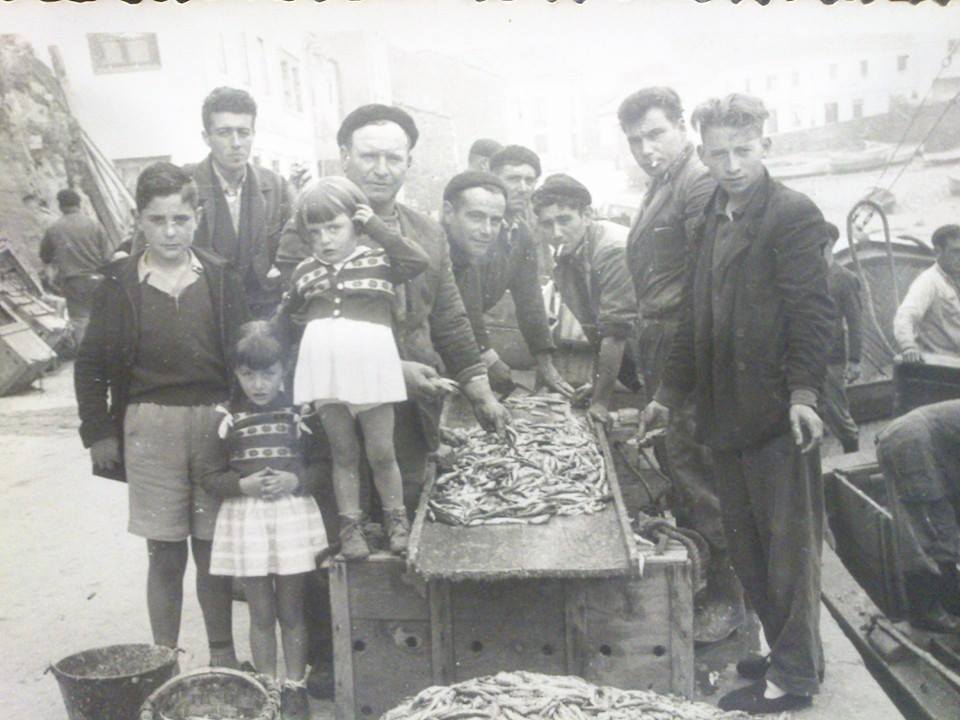 Grupo de pescadores en el muelle de Tapia de Casariego con sus capturas del día