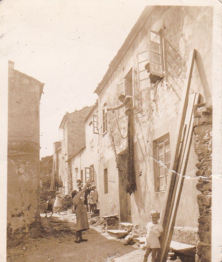 Mujer asomada a la ventana falando con una vecina