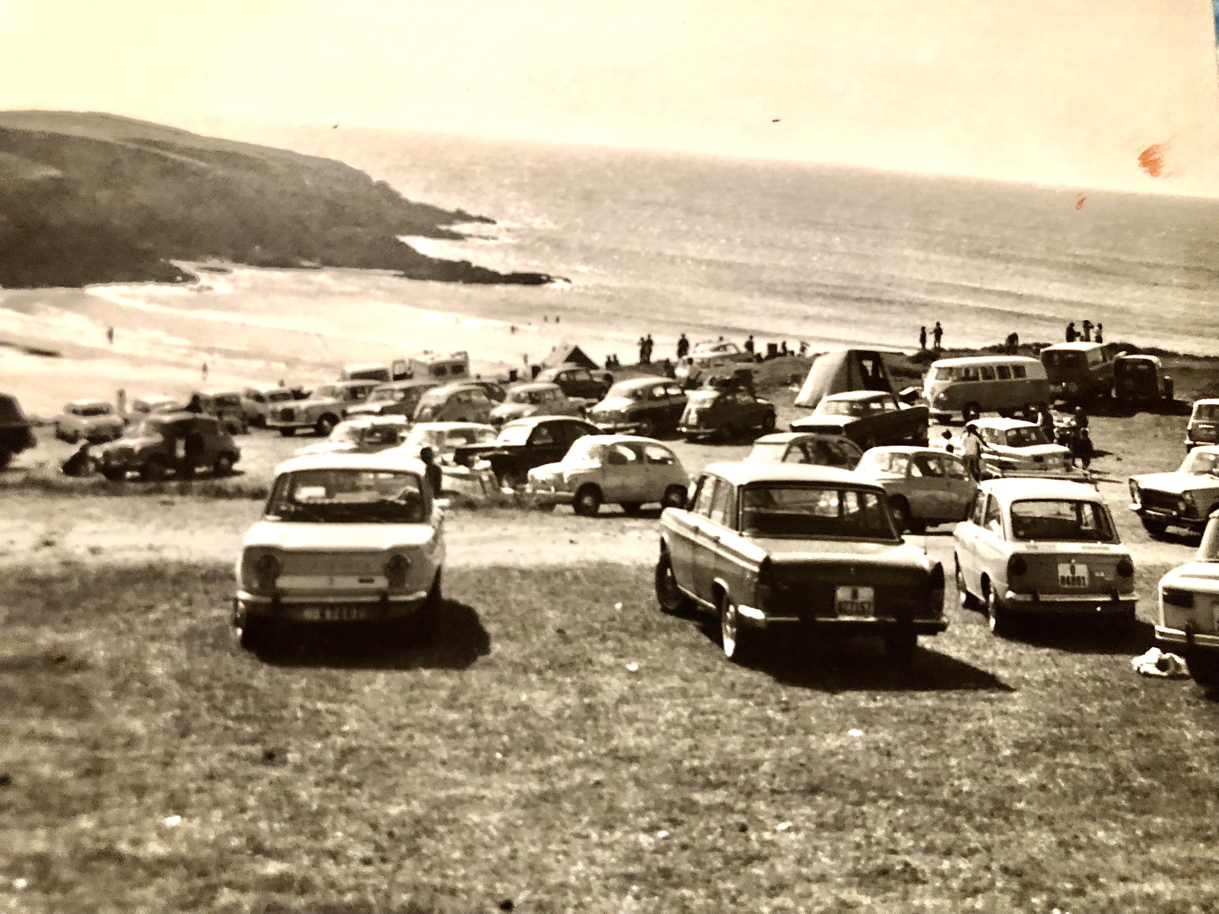 Zona verde encima de playa A Ribeiria llena de coches