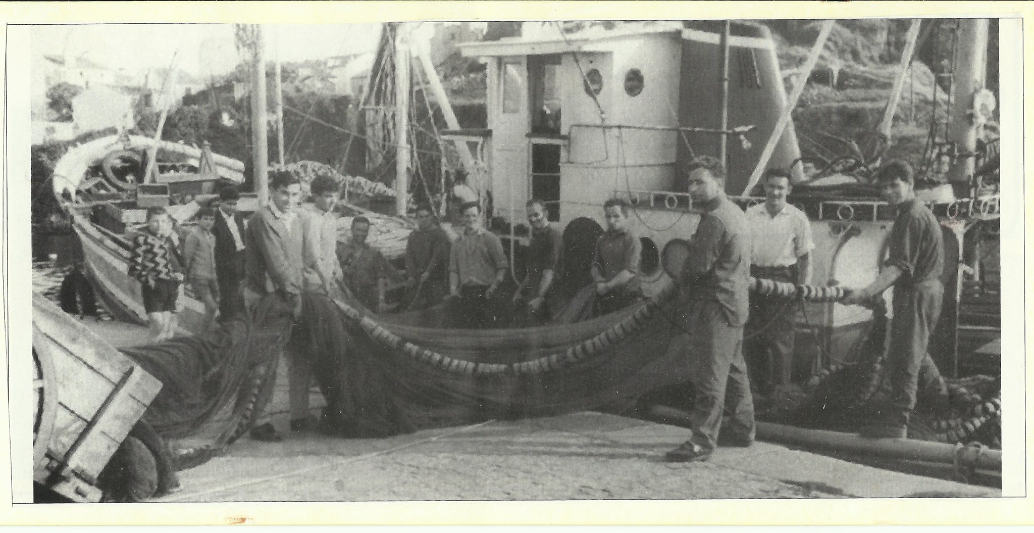 Marineros manejando sus redes de pesca en el puerto de Tapia de Casariego