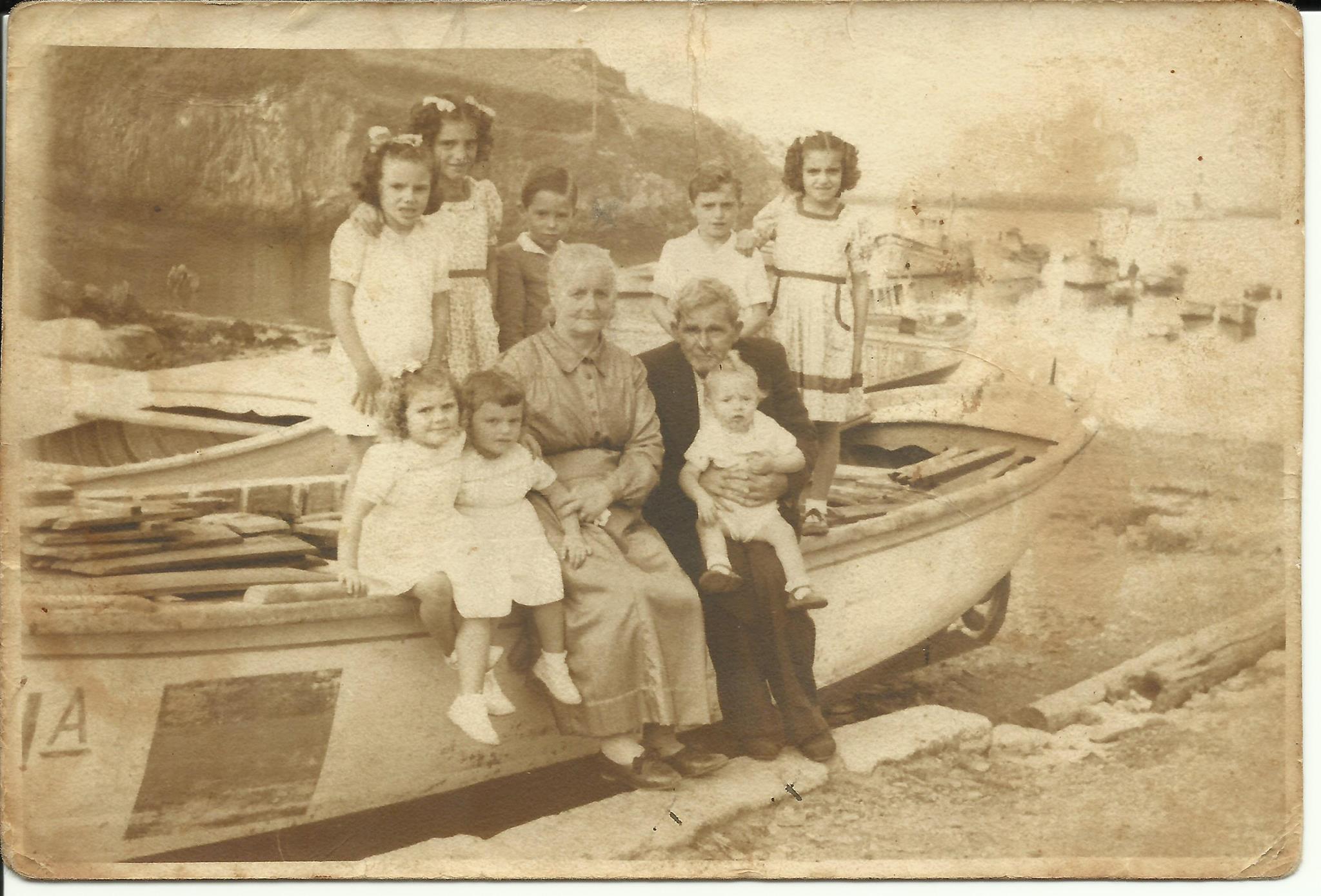 Foto familiar sentados en una lancha en el muelle de Tapia de Casariego