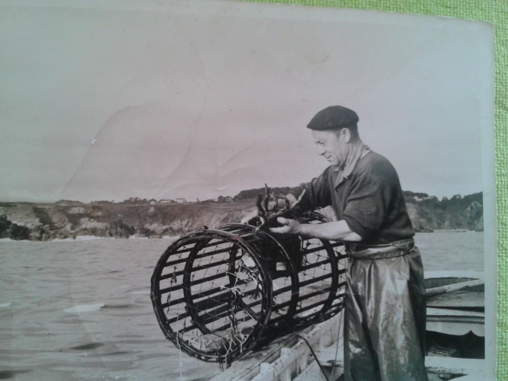 Pescador recogiendo una nasa y revisando el pescado recién capturado