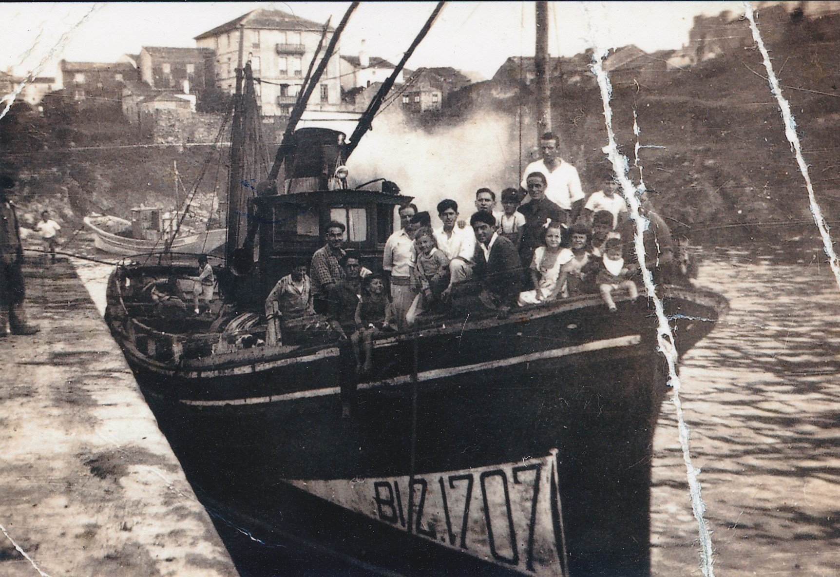 Grupo de personas en un barco de pesca en el muelle de Tapia de Casariego