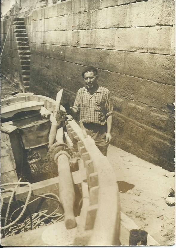 Marinero junto a su lancha en el muelle de Tapia de Casariego